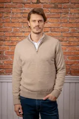 Sweater de punto color beige con medio cierre frontal y cuello alto. Diseño de manga larga con puños y ruedo acanalados.