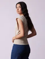 Buzo tejido en hilado fino color beige, con escote en V y sin mangas.