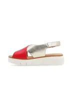 Sandalia de cuero bicolor en tonos rojo y dorado, con tiras cruzadas, hebilla metálica de ajuste en el talón y suela plataforma de poliuretano color blanco.