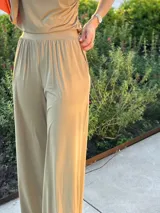 Pantalón de vestir color azul marino, de corte recto, con bolsillos laterales y traseros. Se ajusta a la cintura con cinturón de cuero marrón.