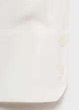 Camisa de corte recto y tejido fluido, con cuello camisero, cierre frontal de botones y mangas largas con puños abotonados.