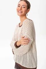 Sweater marrón de tejido calado con lurex en cuello, puños y ruedo. El escote puede usarse de dos formas: mostrando un hombro o de forma clásica.