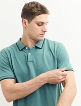 Remera polo azul marino con ribetes blancos en el cuello y en los bordes de las mangas corta, y cierre frontal de botones.