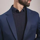 Saco de gabardina azul marino con solapa de muesca, dos botones frontales y bolsillos de parche.