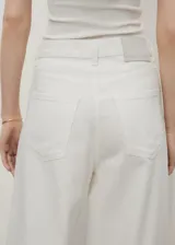 Pantalón de jean estilo wideleg, de tiro alto y corte largo, con diseño de cinco bolsillos, trabillas para cinturón y cierre frontal con cremallera y botón.