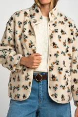 Campera de corderito con estampado floral, cuello alto y cierre frontal con botones a presión. Posee puños elásticos y un diseño de ajuste al cuerpo.
