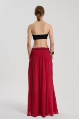Falda larga roja de bambula de algodón, con cintura ancha elástica, recortes y bolsillos delanteros.