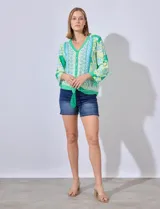 Blusa estampada con escote en V, abertura central con botones y terminación anudada. Largo de manga regulable con presilla y botón.