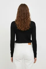 Polera de viscosa a rayas horizontales negras y blancas, de manga larga y cuello alto tipo polera.