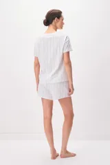 Pijama de algodón compuesto por una remera de manga corta con cuello redondo y un short con cordón ajustable en la cintura, ambos con diseño de rayas verticales formadas por pequeños motivos florales en tonos azules sobre fondo blanco.