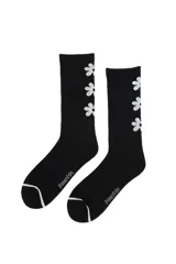 Medias de caña larga color negro, con diseño acanalado y estampado de flores blancas en el lateral. Presentan detalle de línea blanca en la puntera y logo de la marca estampado en el empeine.