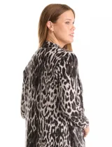 Chaqueta larga de tejido de punto con diseño midi y corte recto. Presenta un patrón de cuadros sutiles, cuello con solapa, frente abierto sin botones y bolsillos de parche delanteros.