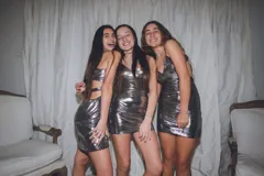 Vestido corto de fiesta color peltre con lentejuelas, escote recto, breteles finos y espalda descubierta. Presenta aberturas laterales en la cintura y frunce central en el busto.