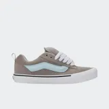 Championes Vans modelo Knu Skool de corte bajo, con diseño robusto inspirado en los años 90. Presentan capellada de gamuza gris, lengüeta y cuello acolchados, cordones anchos blancos y la icónica Sidestripe 3D en color celeste. Incluyen suela vulcanizada blanca con diseño waffle.