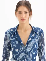 Camisa de mesh elastizado color azul con estampado de cadenas, de manga larga y suave transparencia, con drapeado en el centro delantero.