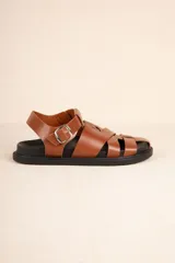 Sandalias bajas tipo gladiador color marrón, con tiras de cuero sintético entrelazadas y hebilla metálica ajustable.