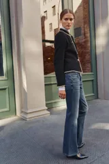 Jeans de tiro bajo y cintura ancha, con diseño bootcut de corte evasé desde la rodilla. Cuenta con cinco bolsillos y cierre frontal con cremallera y dos botones metálicos. Color azul con efecto desgastado.
