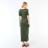 Vestido midi color verde militar, con mangas cortas, cuello redondo y detalle drapeado en la cintura con hebilla metálica dorada circular.