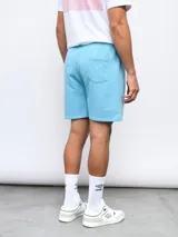 Bermuda de felpa color celeste, con cintura elástica y cordón de ajuste. Presenta el logo Umbro bordado en la pierna izquierda.