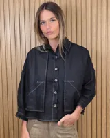 Sobrecamisa negra de lino con costuras a contratono en blanco, cierre frontal con botones, cuello camisero y bolsillos frontales aplicados con solapa.