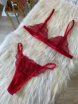 Conjunto de lencería compuesto por un bralette triangular de encaje con breteles regulables y una tanga de encaje regulable con corte media less.
