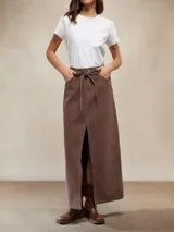Falda larga de denim color marrón chocolate, tiro alto, con lazo de ajuste en la cintura y abertura frontal pronunciada.