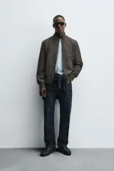 Cazadora de corte regular confeccionada en tejido técnico repelente al agua. Presenta cuello subido, manga larga con puños de rib, bolsillos laterales de vivo y cierre frontal con cremallera.