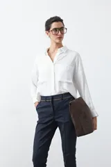 Pantalón de vestir negro de corte recto, con cintura estructurada y costura central vertical en las piernas que aporta un acabado sastrero.