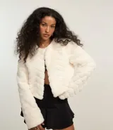 Saco corto de pelo sintético color blanco, con cuello redondo y cierre frontal con ganchos.