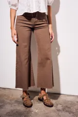 Pantalón de jean color marrón, tiro medio, con corte wide leg y ruedo desflecado.