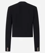 Saco corto de crepé en color negro, con cuello redondo, cierre frontal de botones metálicos y bolsillos con solapa en el frente. Presenta mangas largas y un diseño estructurado.