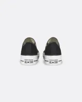 Championes Converse Chuck Taylor All Star Lift OX, modelo de lona color negro con plataforma blanca y suela de goma. Cuenta con cordones blancos, puntera de goma y ojalillos metálicos laterales para mayor ventilación.