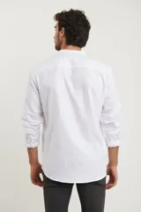 Camisa blanca de manga larga con cuello mao y bolsillo en el pecho.