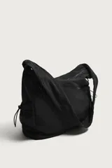 Bolso de hombro negro de nylon, con compartimento principal y bolsillos con cierre de cremallera, bolsillos laterales con cordón ajustable y asa fruncida.