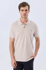 Remera polo de manga corta en color azul melange, con cuello camisero, cierre frontal de dos botones y pequeño bordado en el pecho.