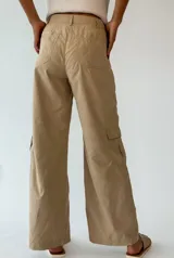 Pantalón cargo violeta de corte ancho, con bolsillos laterales y cintura con cinturón trenzado blanco.