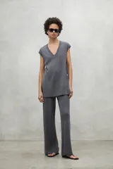 Chaleco de punto color gris, confeccionado en lino, con escote en V, corte holgado y aberturas laterales.