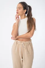 Pantalón de tela color beige, con cintura alta elastizada y cordón ajustable.