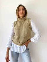 Chaleco tejido a mano color beige con cuello alto y sisas amplias.