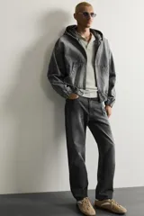 Pantalón de jean corte slim fit con efecto lavado, tiro medio, cinco bolsillos y cierre frontal con cremallera y botón.