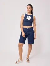 Bermuda de jean azul oscuro, corte recto y largo hasta la rodilla. Confeccionada en denim 100% algodón, con bolsillos delanteros y traseros.