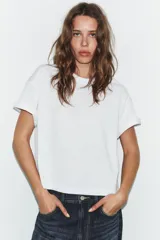 Camiseta de corte holgado confeccionada en algodón, con cuello redondo, manga corta con dobladillo y bajo recto.