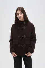 Campera tipo duffle coat de lana en color verde oliva, con capucha, cierre frontal mediante botones tipo toggle y bolsillos delanteros con solapa.