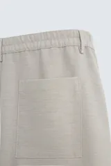 Bermuda de algodón color blanco, de corte relajado, con cintura elástica, bolsillos frontales y bolsillos traseros de plastrón. Cierre frontal con cremallera y botón.