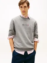 Buzo de cuello redondo Tommy Hilfiger, color gris melange, con diseño clásico y detalles acanalados en cuello, puños y bajo. Cuenta con un pequeño logo gráfico estampado y bordado en el centro del pecho.