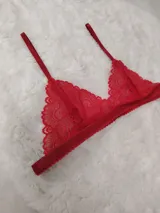 Bralette de encaje rojo con diseño triangular y tirantes ajustables finos.