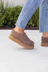 Suecos cerrados de cuero color visón (marrón topo), con suela plataforma gruesa de goma color caramelo. Diseño sin cordones ni cierres visibles.