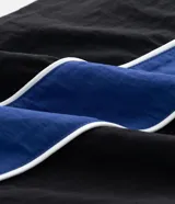Pantalón deportivo de corte recto confeccionado en microfibra de poliamida, color negro con paneles laterales en color violeta y detalles en blanco. Cuenta con cintura elástica con cordón ajustable.