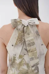 Vestido corto con estampado floral en tonos beige, verde y marrón, con cuello halter y lazo.