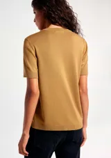 Blusa de manga corta confeccionada en tejido de punto, color negro, con cuello redondo y diseño clásico.